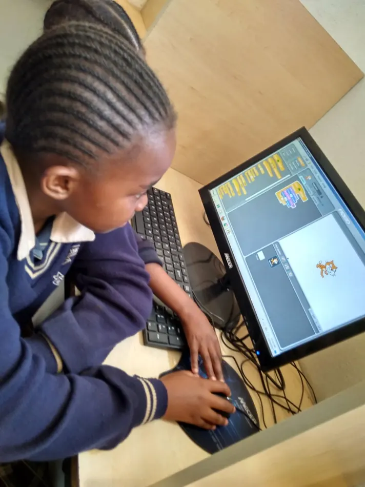 A schoolgirl builds her first Scratch program during a GEM computer lab session.