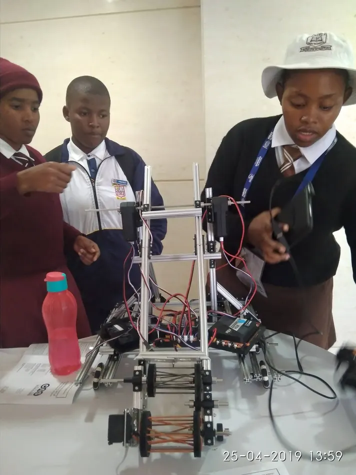 Students test and adjust a competition robot at a GEM robotics programme.