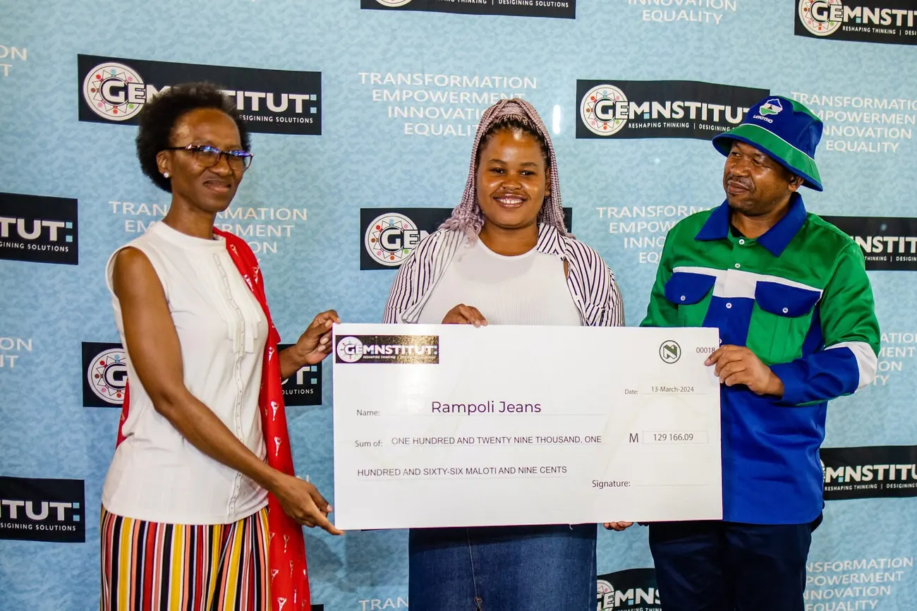 A young entrepreneur receives a M129,166 grant cheque for Rampoli Jeans at a GEM Institute ceremony.